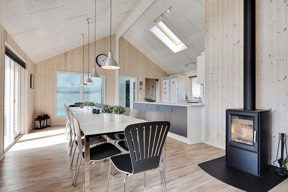 In dem Wohnzimmer finden Sie eine gemütliche Sitzecke, einen Holzofen, und einen großen Esstisch, an dem alle Gäste mit Blick auf den Poolbereich zusammen sitzen können.
