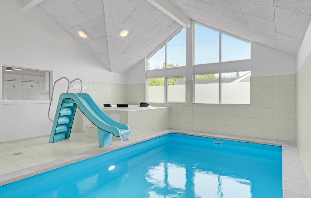 Das Ferienhaus 323 hat einen schicken Poolbereich mit Wasserrutsche, einem geräumigen, eingelassenen Whirlpool und einer Sauna.