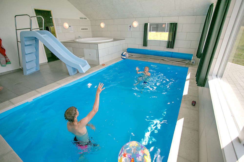 Das Ferienhaus 353 hat einen schicken Poolbereich mit Wasserrutsche, einem geräumigen, eingelassenen Whirlpool und einer Sauna.