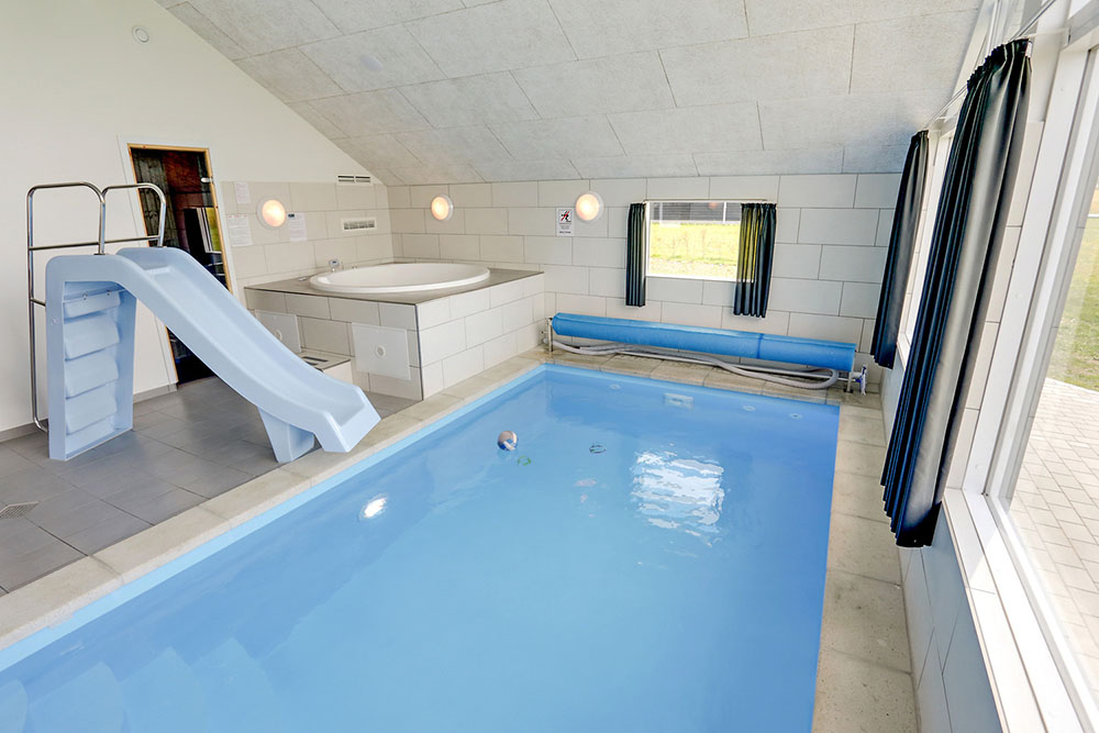 Das Ferienhaus 355 hat einen schicken Poolbereich mit Wasserrutsche, einem geräumigen, eingelassenen Whirlpool und einer Sauna.