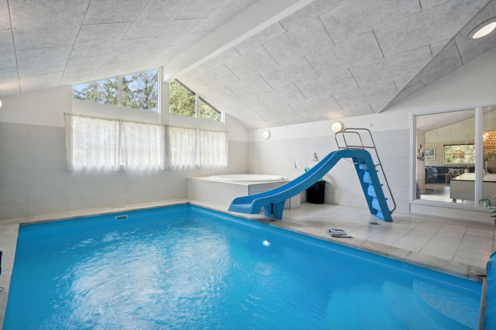 Das Ferienhaus 371 hat einen schicken Poolbereich mit Wasserrutsche, einem geräumigen, eingelassenen Whirlpool und einer Sauna.