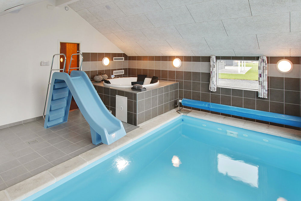 Das Ferienhaus 702 hat einen schicken Poolbereich mit Wasserrutsche, einem geräumigen, eingelassenen Whirlpool und einer Sauna.