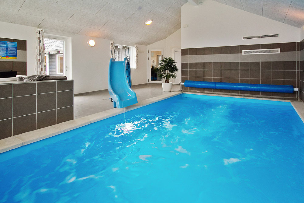 Das Ferienhaus 703 hat einen schicken Poolbereich mit Wasserrutsche, einem geräumigen, eingelassenen Whirlpool und einer Sauna.