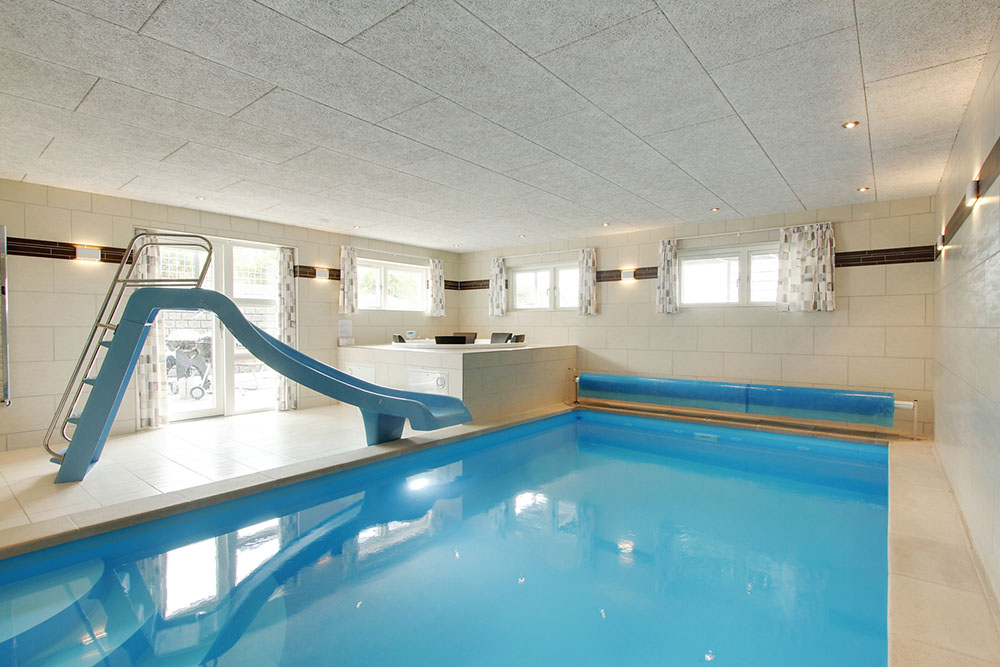 Das Ferienhaus 400 hat einen schicken Poolbereich mit Wasserrutsche, einem geräumigen, eingelassenen Whirlpool und einer Sauna.