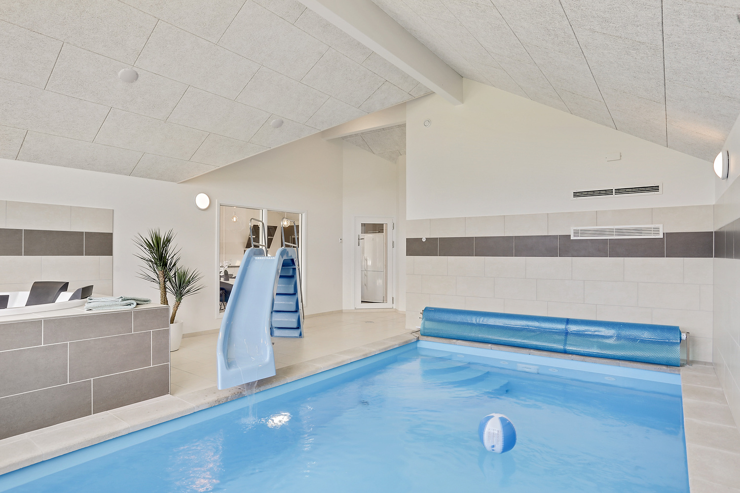 Das Ferienhaus 405 hat einen schicken Poolbereich mit Wasserrutsche, einem geräumigen, eingelassenen Whirlpool und einer Sauna.