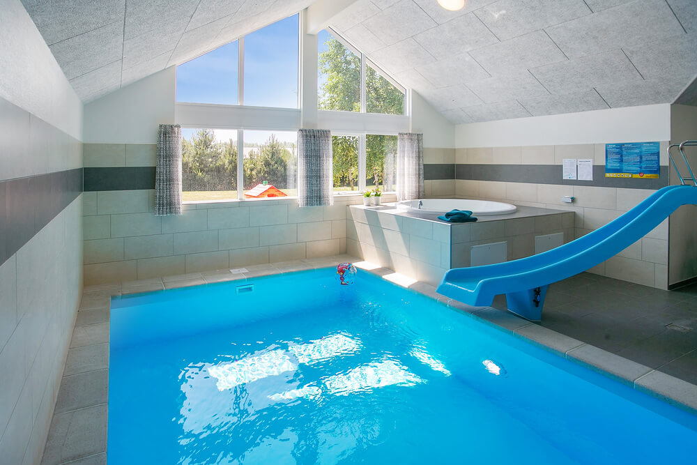Das Ferienhaus 413 hat einen schicken Poolbereich mit Wasserrutsche, einem geräumigen, eingelassenen Whirlpool und einer Sauna.