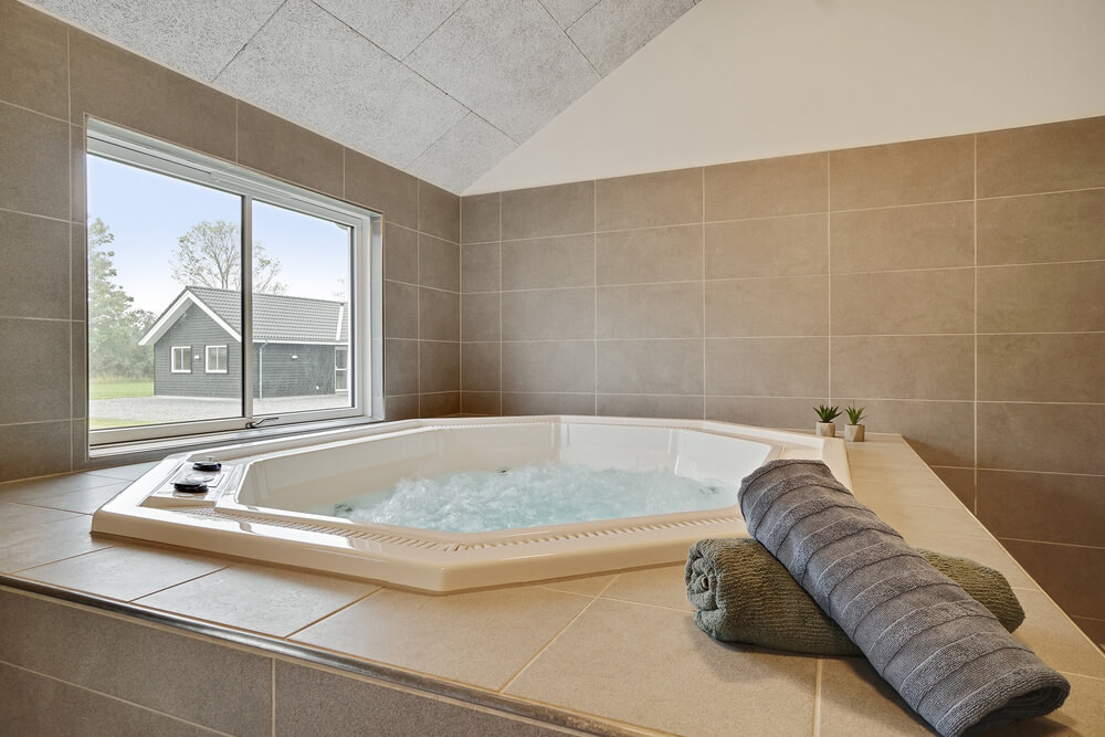 Genießen Sie den warmen Whirlpool im Luxusferienhaus Nr. 448 in Ostjütland
