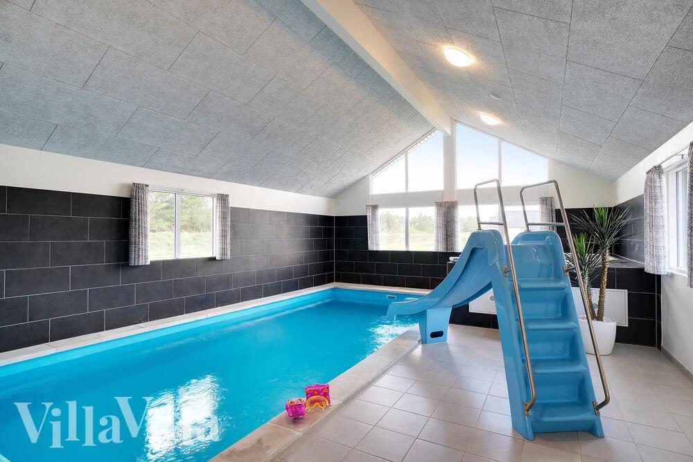 Das Ferienhaus 454 hat einen schicken Poolbereich mit Wasserrutsche, einem geräumigen, eingelassenen Whirlpool und einer Sauna.
