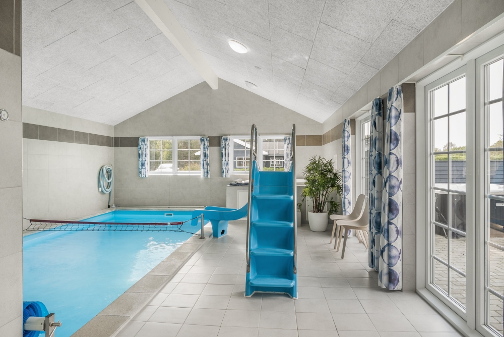 Das Ferienhaus 500 hat einen schicken Poolbereich mit Wasserrutsche, einem geräumigen, eingelassenen Whirlpool und einer Sauna.
