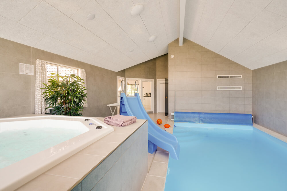 Das Ferienhaus 491 hat einen schicken Poolbereich mit Wasserrutsche, einem geräumigen, eingelassenen Whirlpool und einer Sauna.