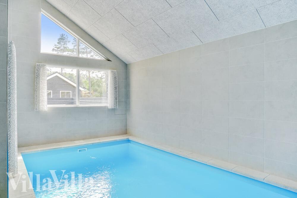 Das Ferienhaus 515 hat einen schicken Poolbereich mit Wasserrutsche, einem geräumigen, eingelassenen Whirlpool und einer Sauna.