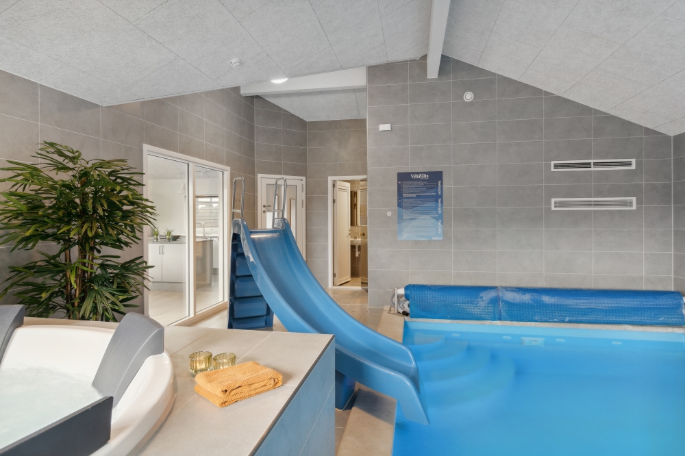 Das Ferienhaus 577 hat einen schicken Poolbereich mit Wasserrutsche, einem geräumigen, eingelassenen Whirlpool und einer Sauna.