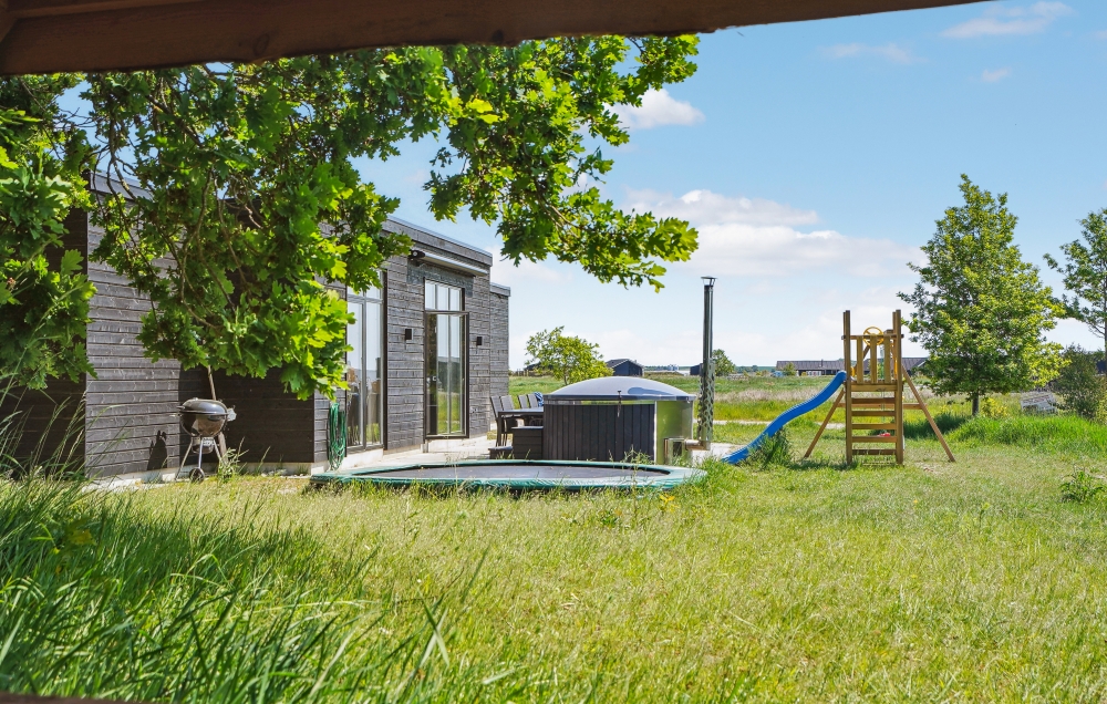 Zu dem attraktiven Ferienhaus Nr. 581 in Ostjütland gehört auch ein tolles Angebot im Außenbereich, z. B. Spieleturm und Schaukeln