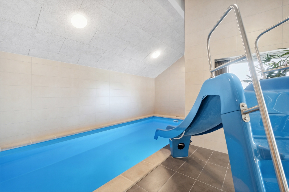 Das Ferienhaus 590 hat einen schicken Poolbereich mit Wasserrutsche, einem geräumigen, eingelassenen Whirlpool und einer Sauna.