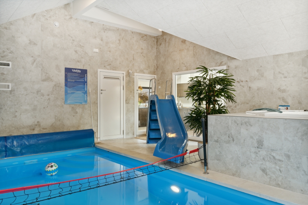 Das Ferienhaus 584 hat einen schicken Poolbereich mit Wasserrutsche, einem geräumigen, eingelassenen Whirlpool und einer Sauna.
