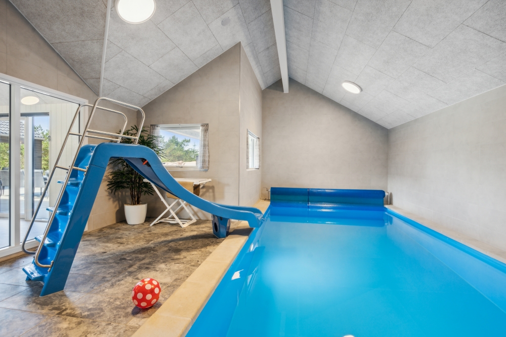 Das Ferienhaus 585 hat einen schicken Poolbereich mit Wasserrutsche, einem geräumigen, eingelassenen Whirlpool und einer Sauna.