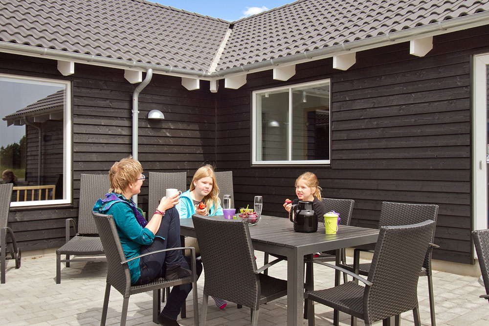 Der dänische Sommer lässt sich auf der großen Terrasse genießen. Für die Kleinsten stehen Sandkiste und Schaukeln parat