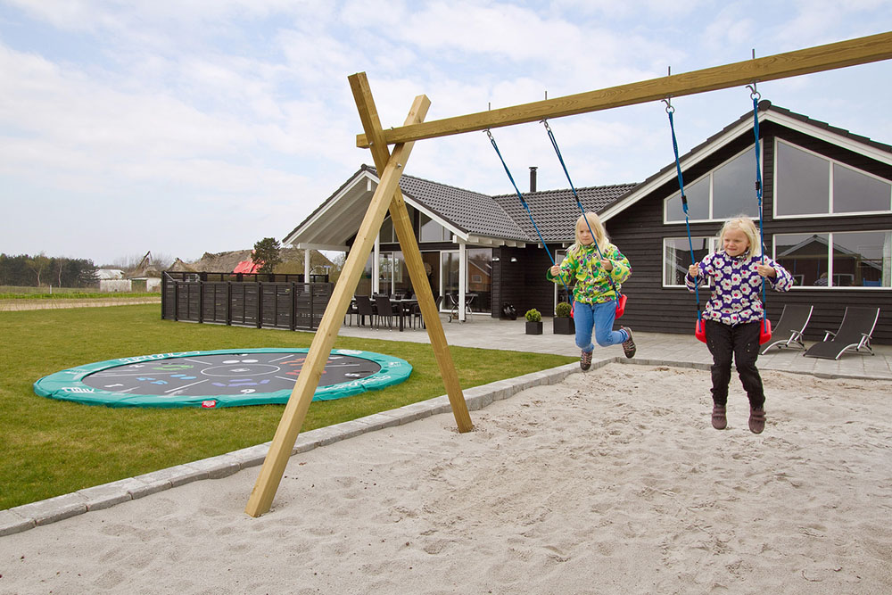 Die große Terrasse eignet sich perfekt für ein Sonnenbad oder ein leckeres Barbecue. Kinder genießen derweil die frische Luft in der Sandkiste, auf den Schaukeln oder im Spielturm