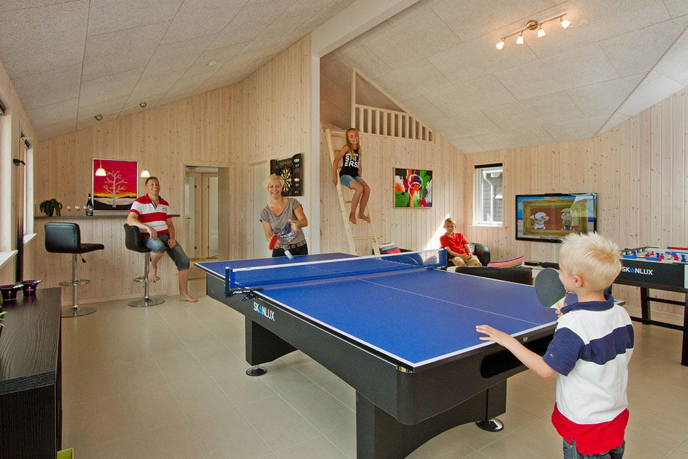 Sportliche Gäste treten im Aktivitätenraum gegeneinander in Billard/ Tischtennis, Kicker und Dart an
