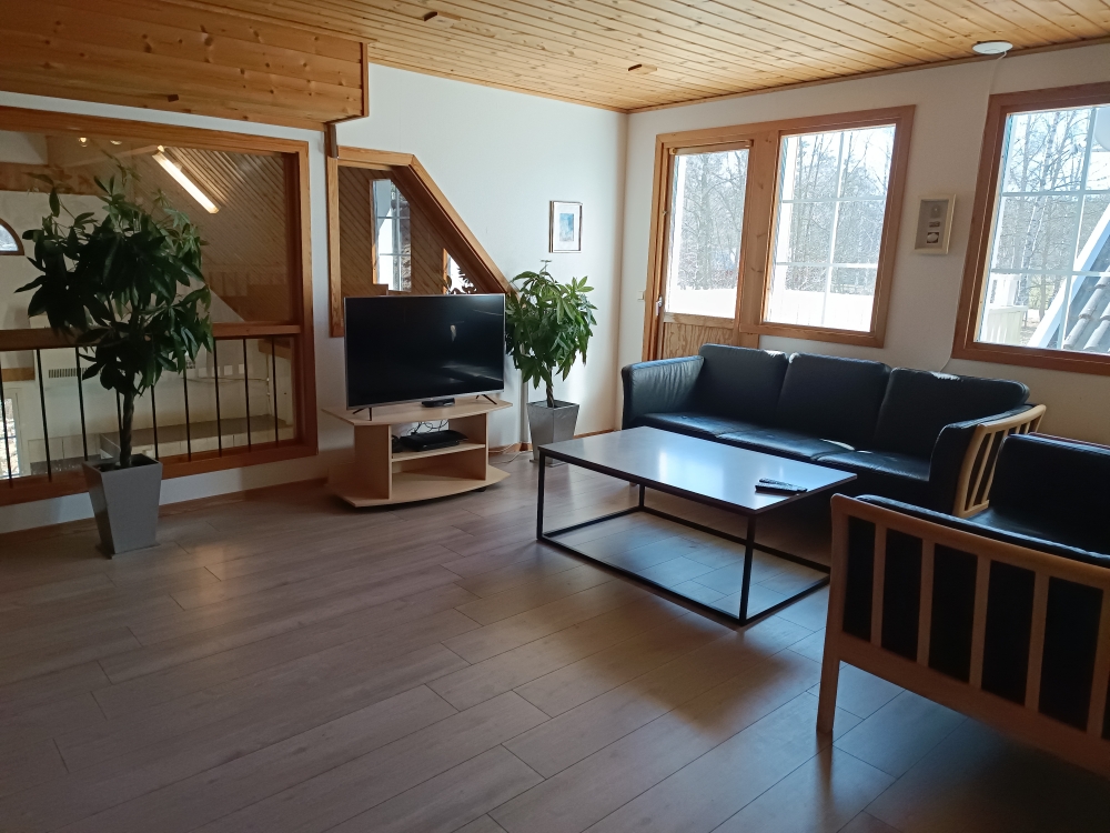 Das Wohnzimmer in der ersten Etage ist mit zwei Sofagruppen ausgestattet und bietet Sicht auf den Poolbereich. Hier befindet sich auch der Zugang zum Balkon