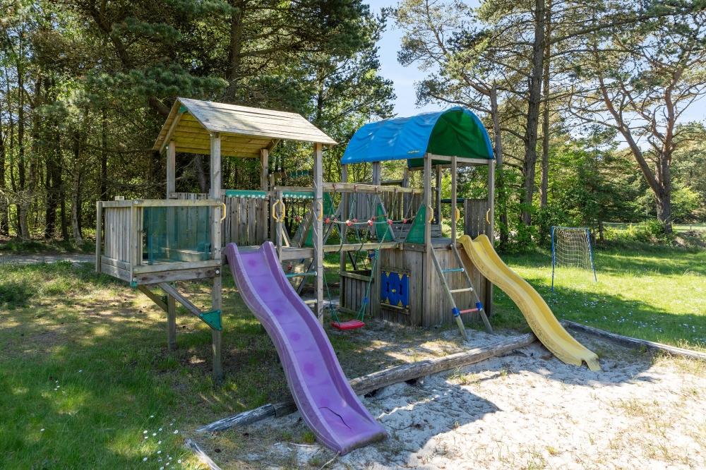 Zu dem attraktiven Ferienhaus Nr. 261 in Westjütland gehört auch ein tolles Angebot im Außenbereich, z. B. Spieleturm und Schaukeln