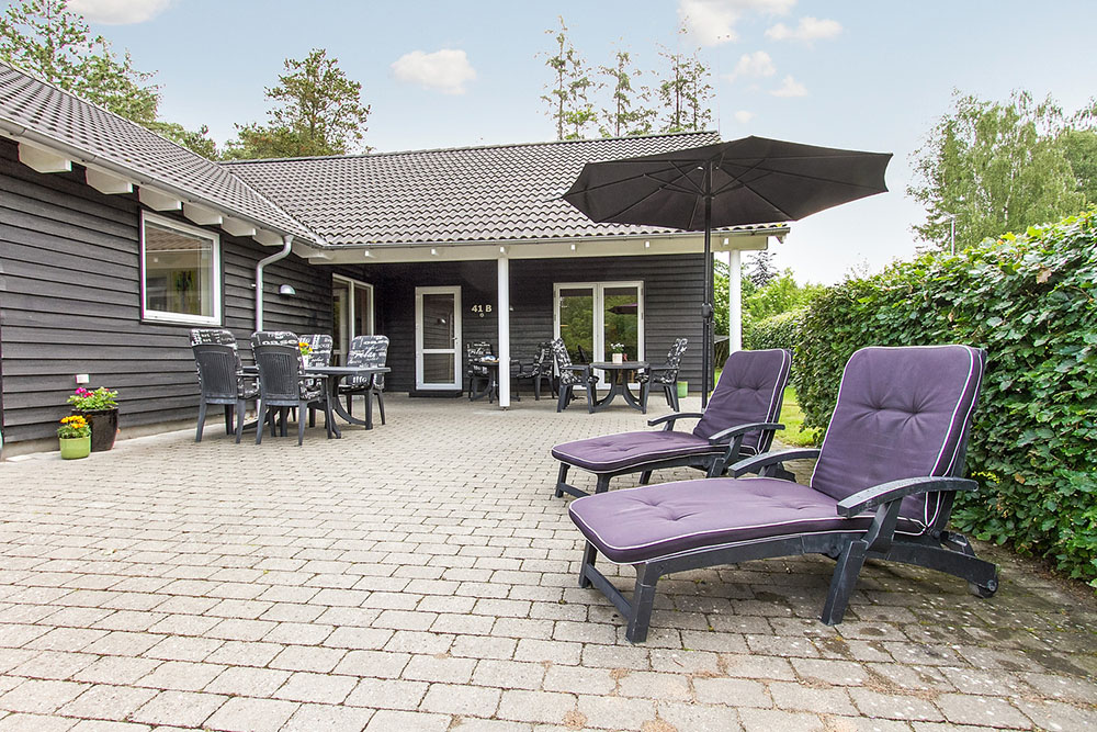 Auf der großen Terrasse können die Sommertage in guten Gartenmöbeln genossen werden, während sich die Kinder beim Spielen auf dem Rasen, im Spielhaus oder in der Sandkiste vergnügen