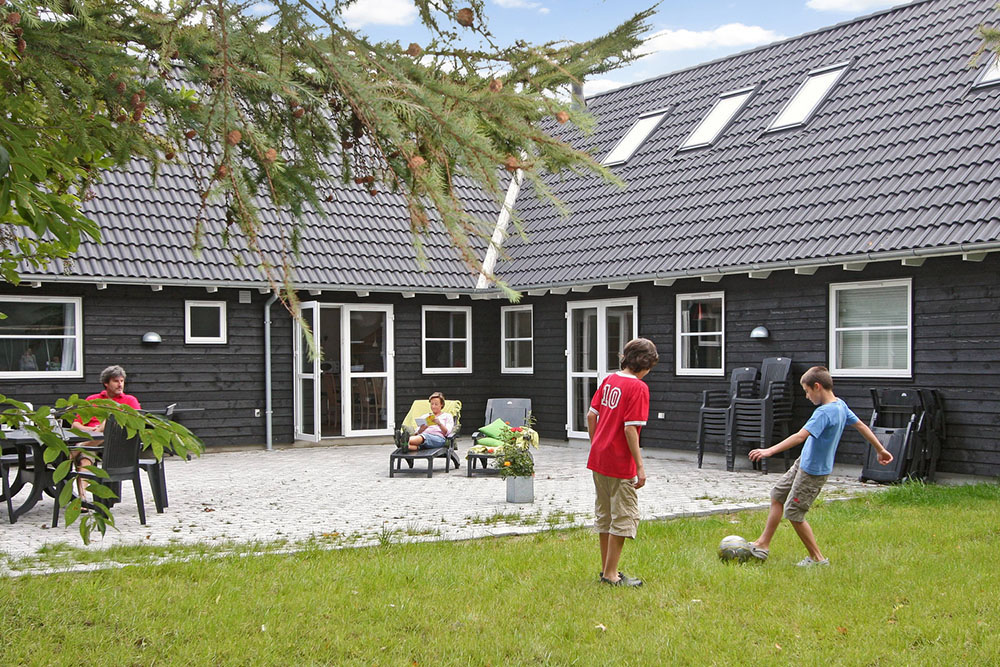 Der Garten ist angenehm mit Bäumen und Büschen umschlossen. Für die kleinsten Gäste stehen Schaukeln sowie eine Sandkiste bereit