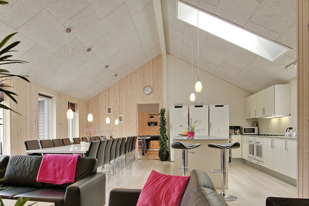 Das Haus hat einen großen Aufenthaltsraum mit Küche, Speiseplätzen und einer Sofagruppe mit Kaminofen